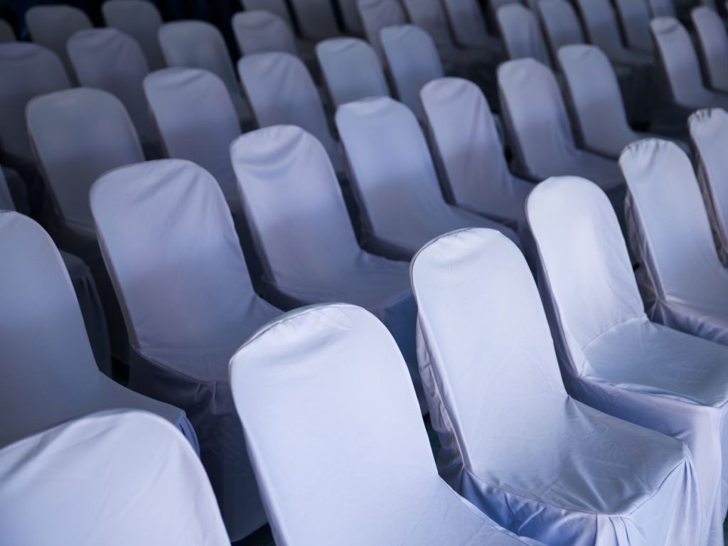 Rangées de chaises habillées de housses blanches