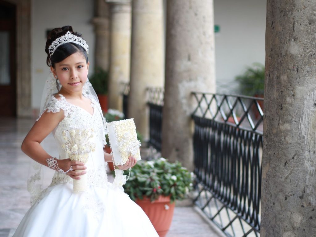 Jeune fille en robe blanche pour sa première communion
